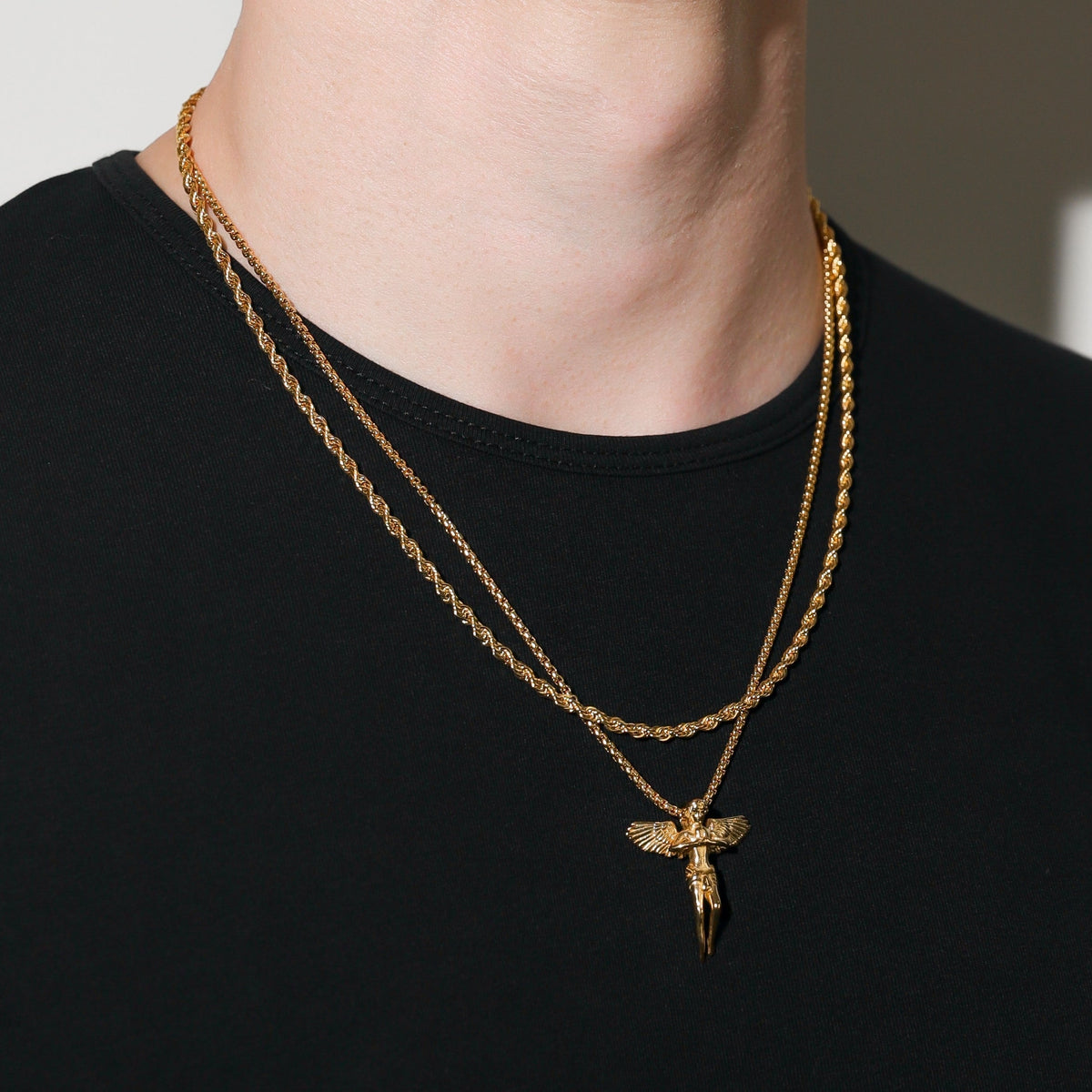 Gold rope chain necklace with guardian angel pendant on a medium-length chain