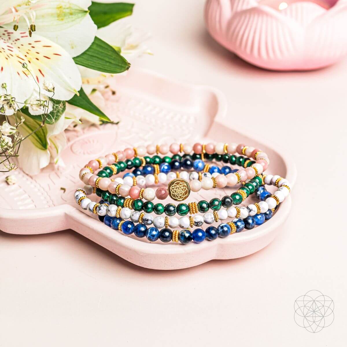 Beaded bracelet set with blue, green, white, and pink stones and gold charm