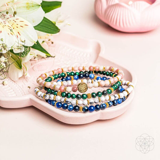 Beaded bracelet set with blue, green, white, and pink stones and gold charm