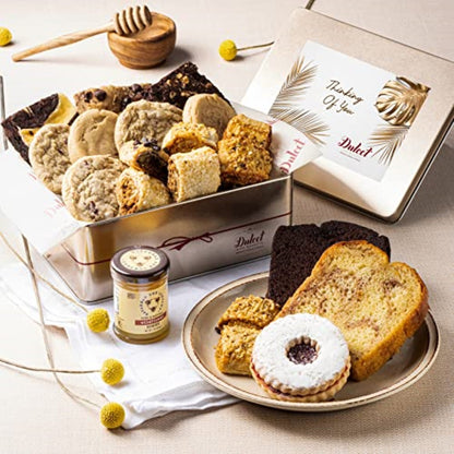 Deluxe honey pastry gift tin with assorted cookies, shortbread, and cake slices on plate