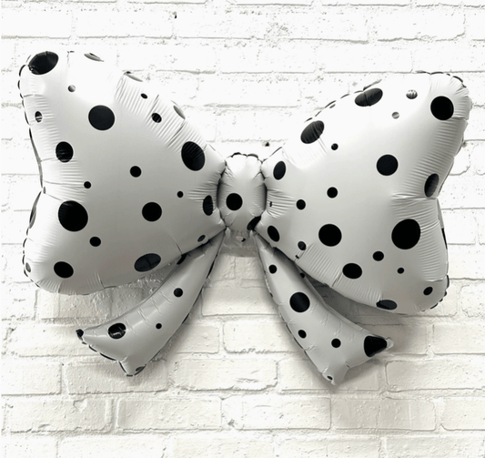 White polka dot bow balloon with black dots, crinkled foil style.