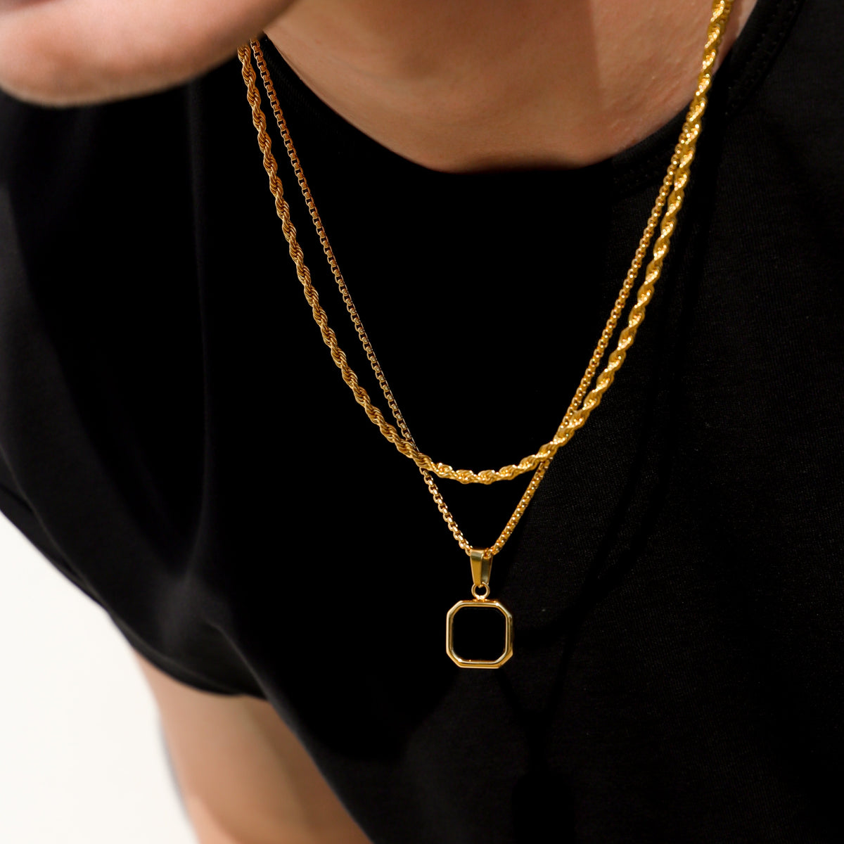 Gold layered chain necklace with square black onyx pendant centerpiece