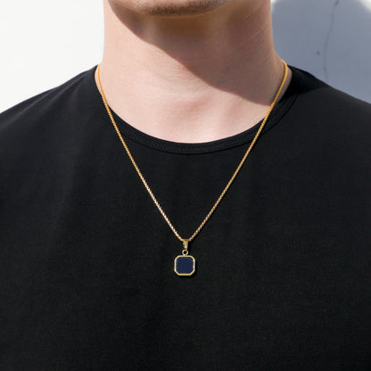 Gold-tone chain necklace with black octagon pendant centered on the chest