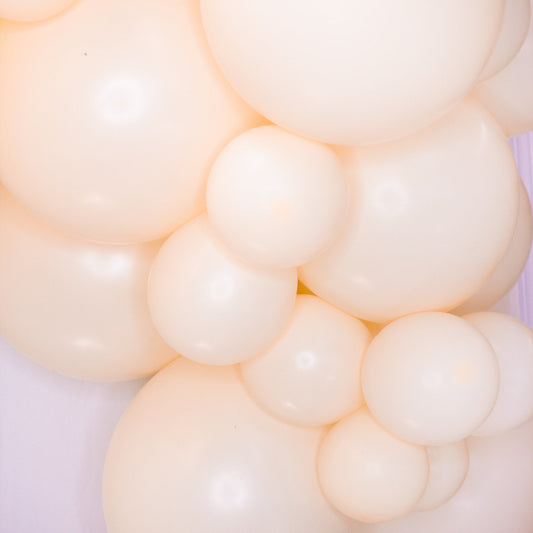 Close-up of blush and cream balloon garland clusters with rounded balloon surfaces
