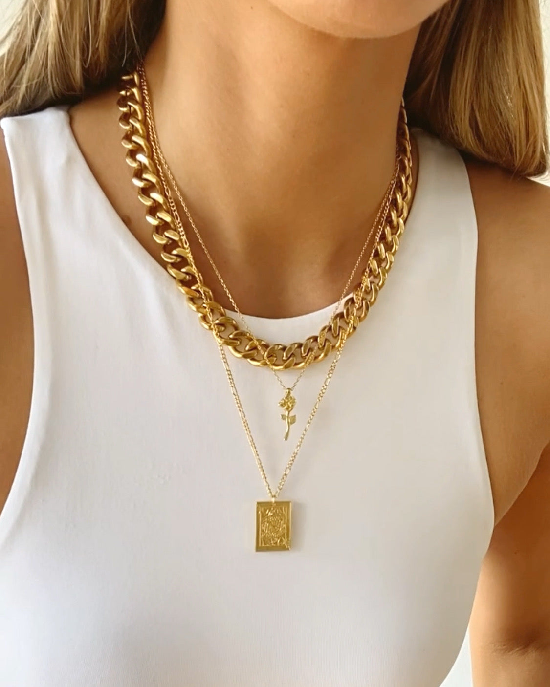 Gold chunky curb chain necklace with square pendant charm on a white top