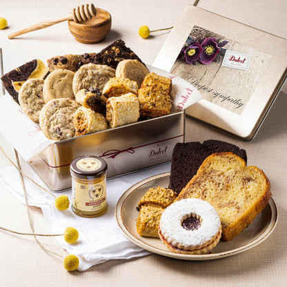 Deluxe honey pastry gift tin with cookies, cake slices, and floral gift card