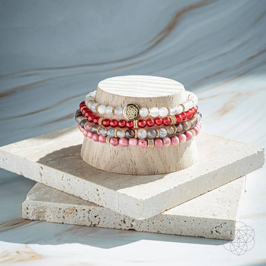 Stack of beaded wrap bracelets with white, pink, and red stones and gold accents