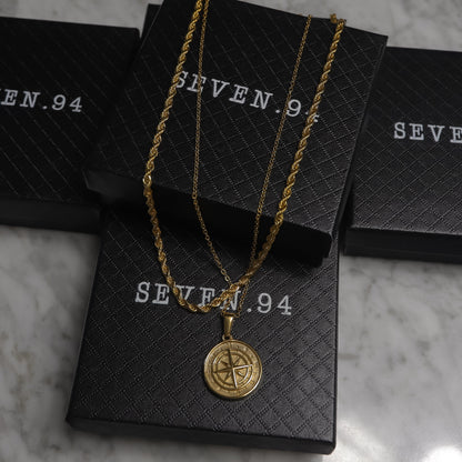 Gold compass pendant necklace set in black gift bags