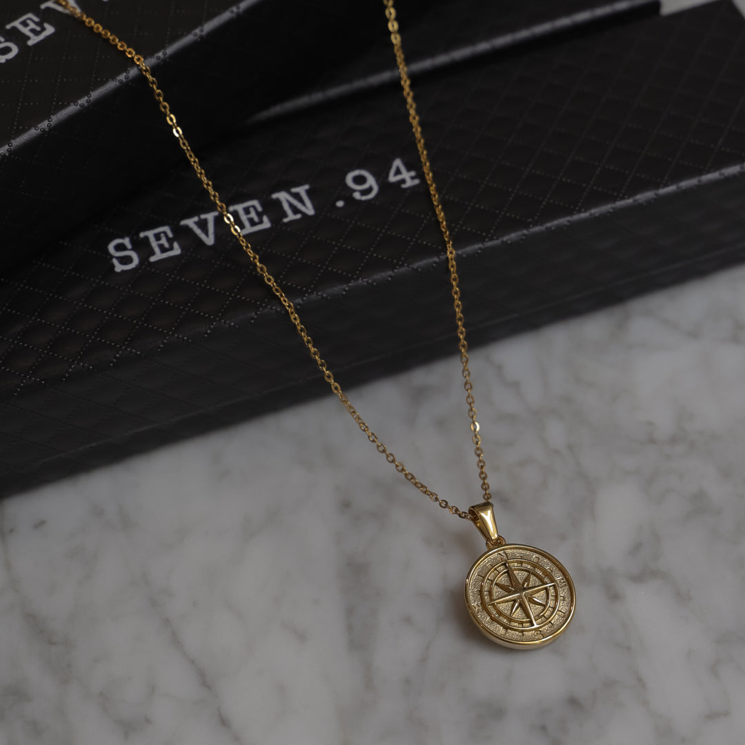 Gold compass pendant necklace with round compass rose medallion and link chain