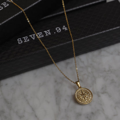 Gold compass pendant necklace with round compass rose medallion and link chain