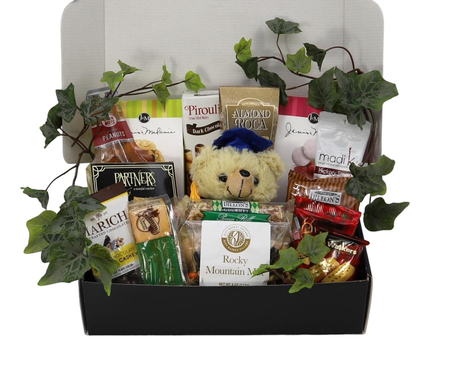 Open graduation gift box with plush teddy, snack packages, and green leaf decor
