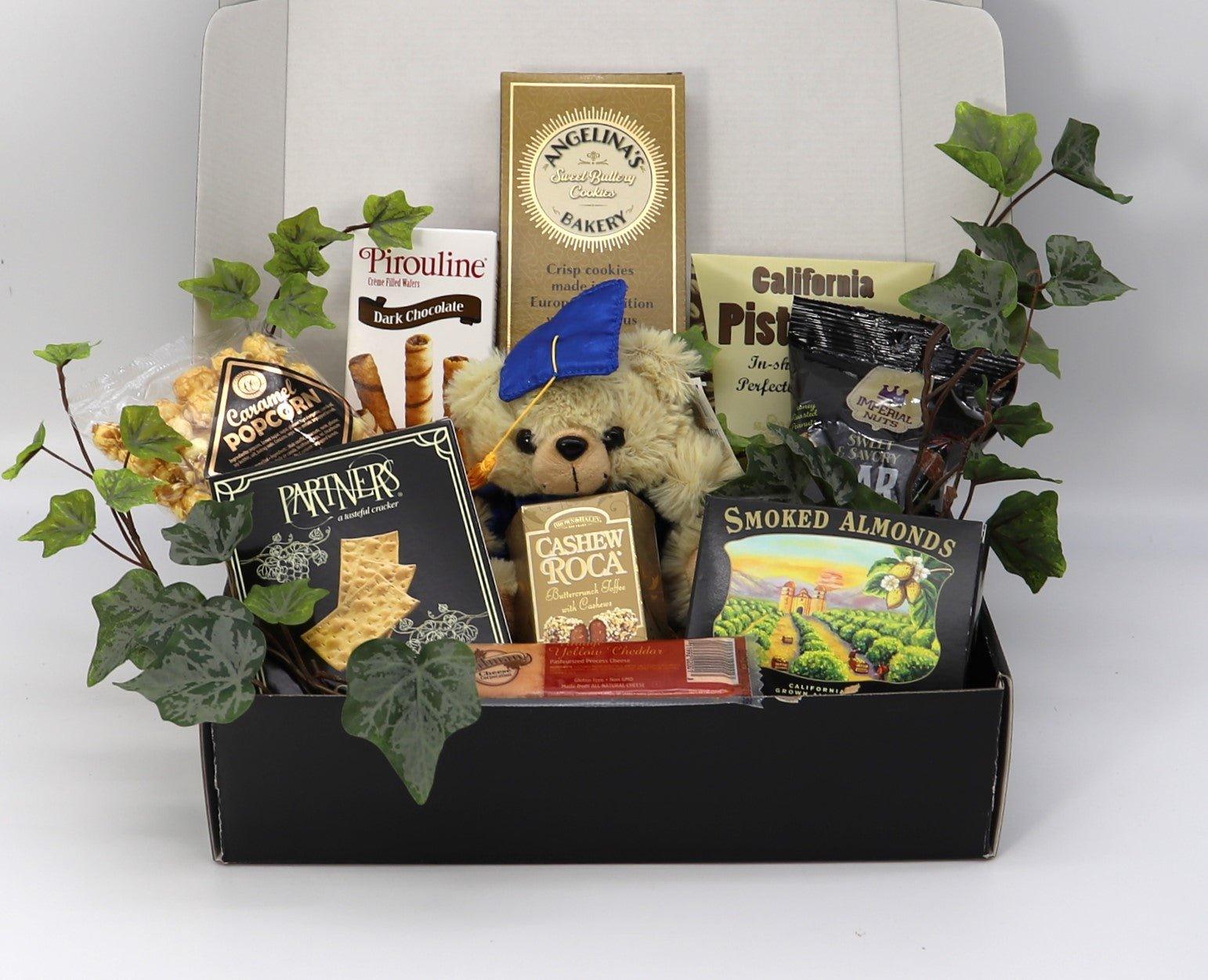 Open graduation gift box with plush teddy and assorted cookies, nuts, and snack bars