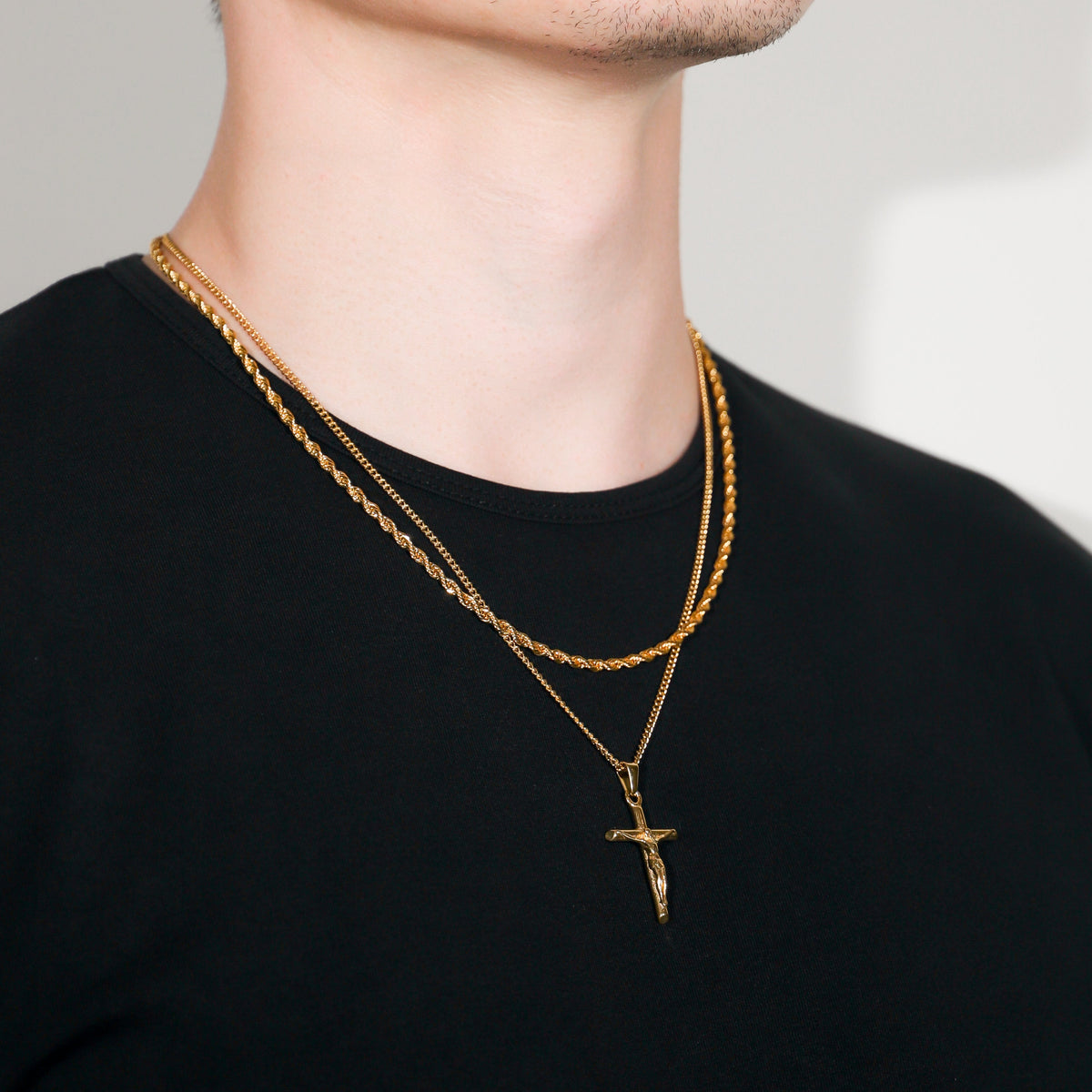 Gold crucifix pendant necklace with layered rope chain and cross pendant