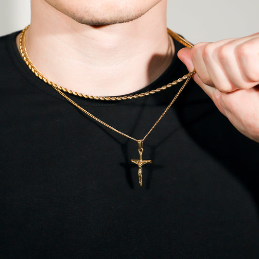 Gold crucifix pendant on rope chain necklace set, close-up at the collar