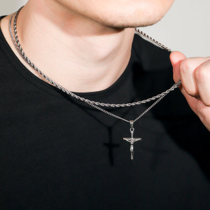 Silver crucifix pendant necklace set with cross charm on rope chain, close-up