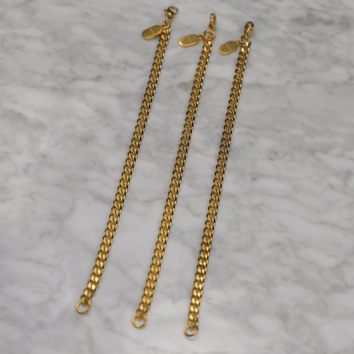 Three gold Cuban link bracelet chains with clasp ends