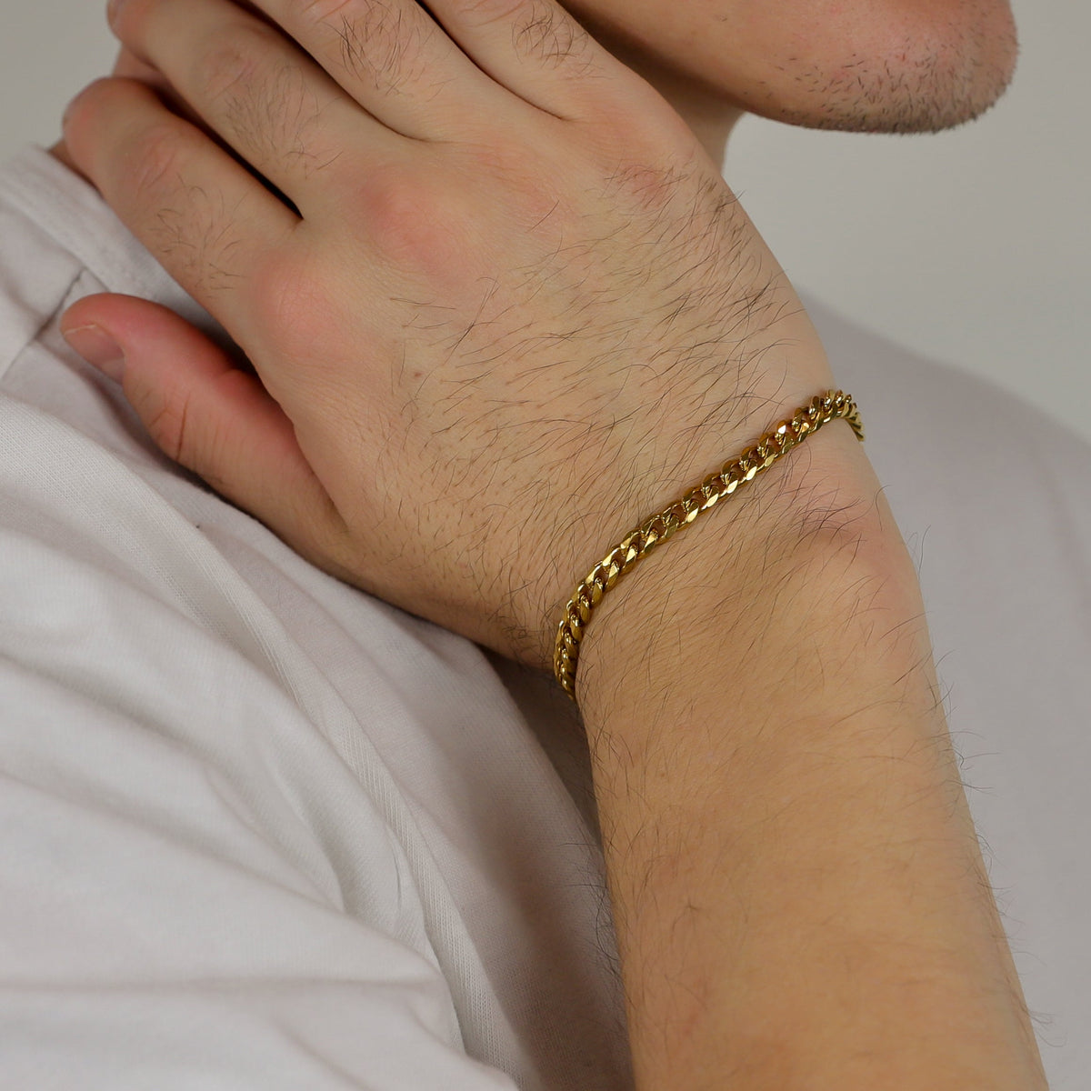 Gold Cuban link bracelet on forearm and wrist