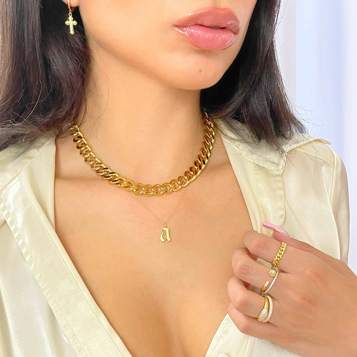 Gold chunky curb chain necklace with dangling pendant, worn at neckline