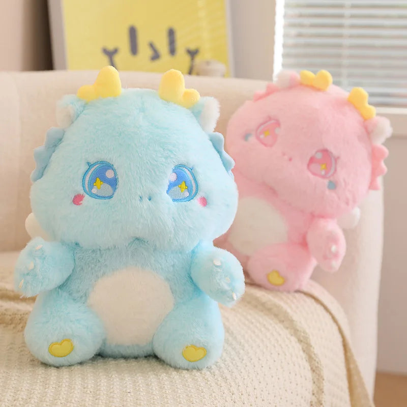 Light blue baby dragon plush with star-eyed embroidery and yellow horn tips