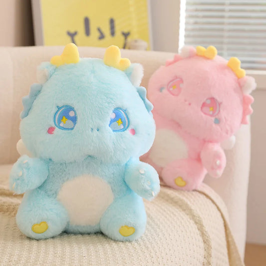 Light blue baby dragon plush with star-eyed embroidery and yellow horn tips