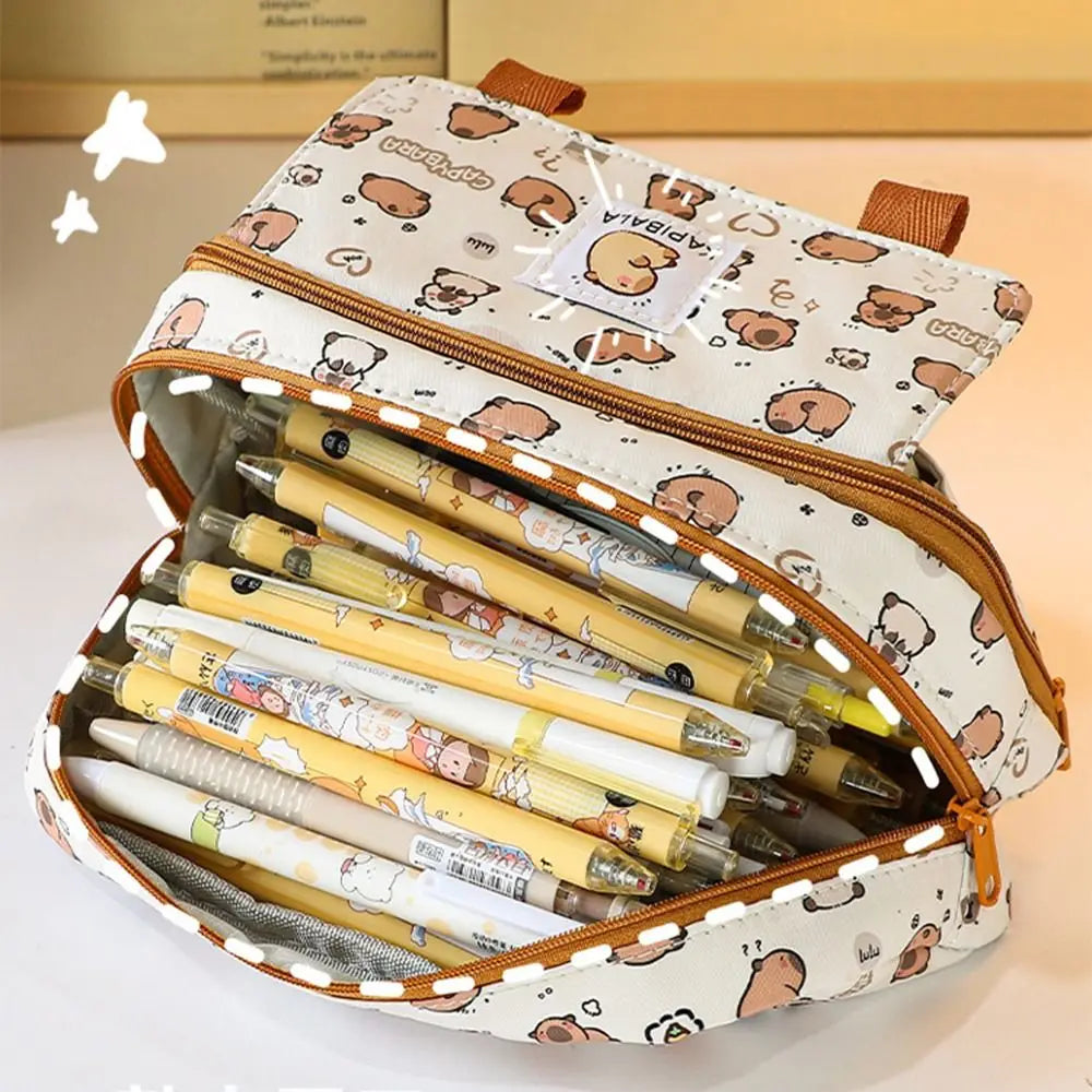 Open capybara pattern pencil bag showing multiple compartments and orange zipper binding