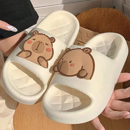 White capybara slide sandals with brown cartoon face on wide strap.