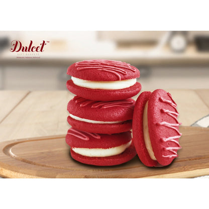Stack of red macarons with white filling and one halved cookie