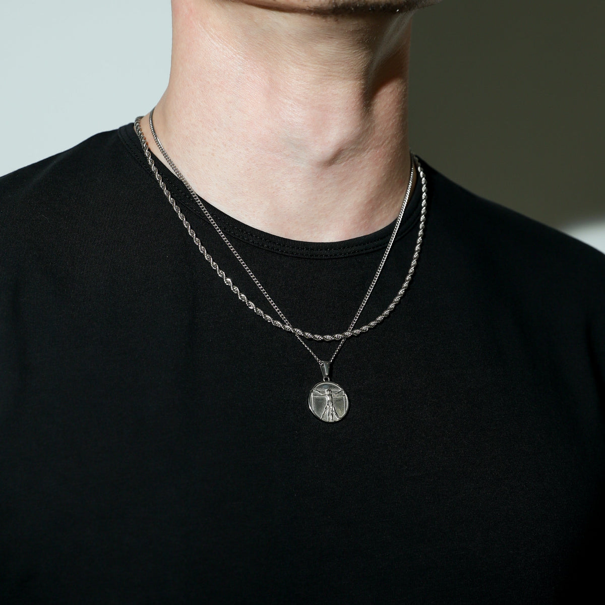 Silver-tone double-layer chain necklace with circular pendant and small charm below