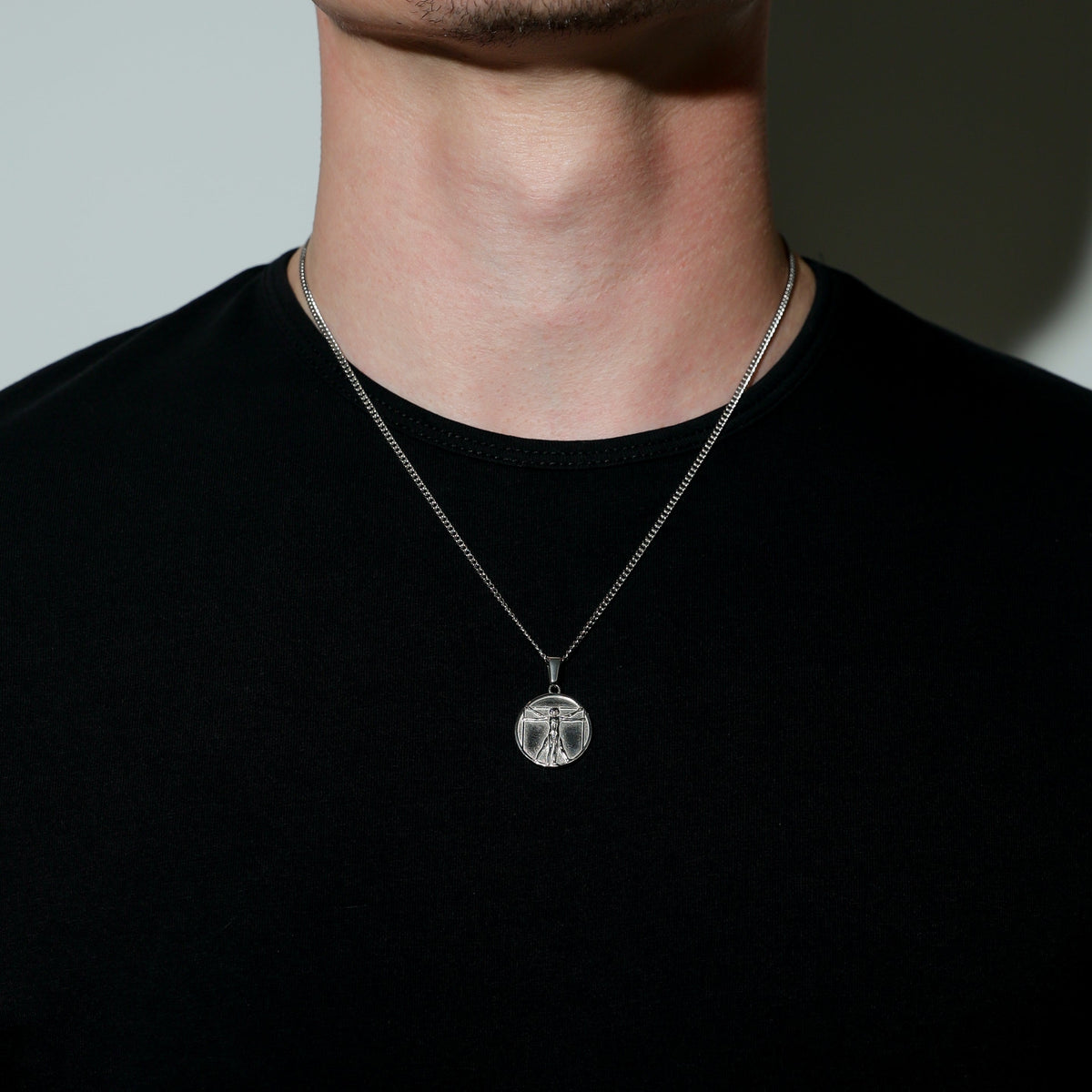 Silver rope chain with circular Vitruvian Man pendant, engraved figure in center