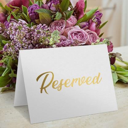 White reserved table tent sign with gold “Reserved” text on the front panel