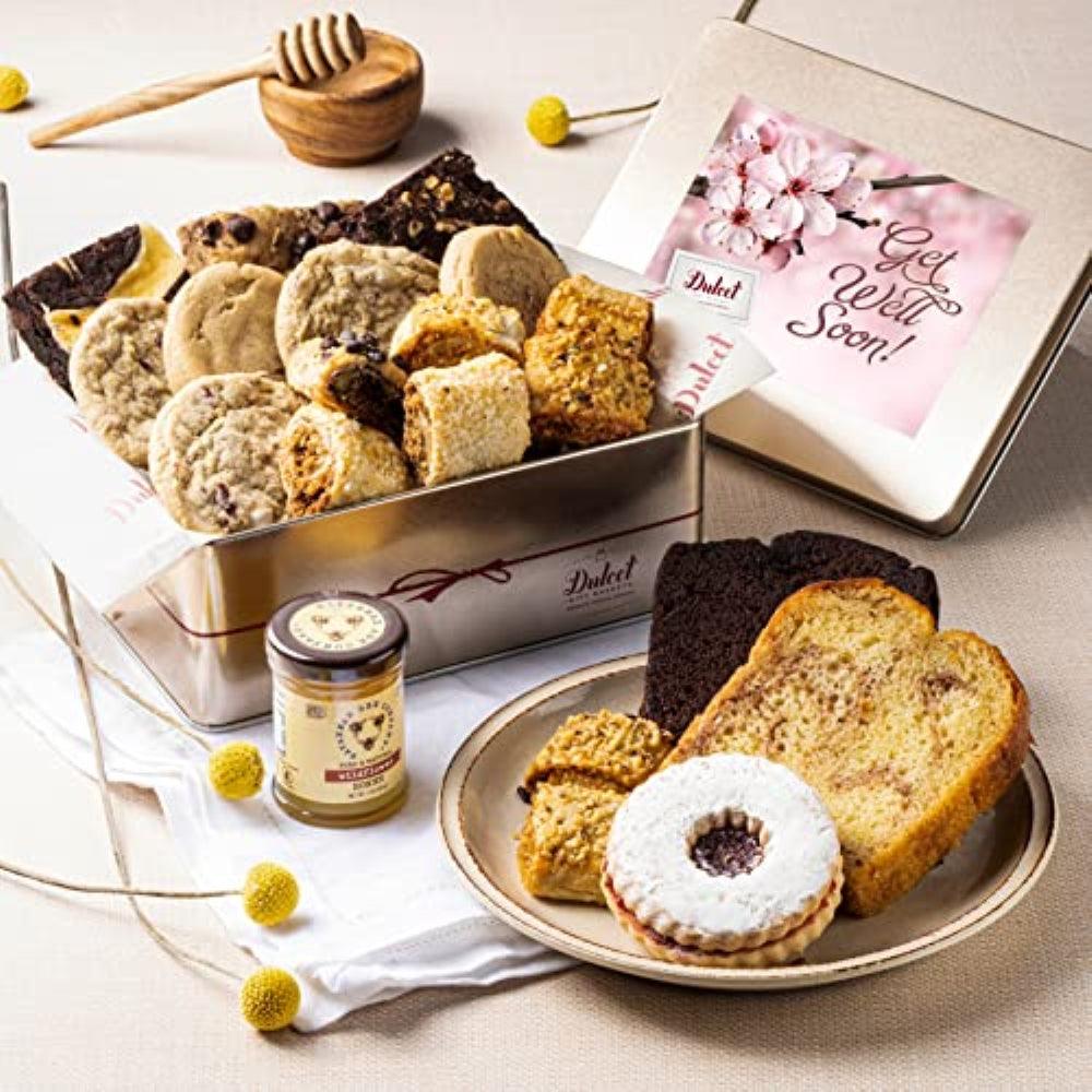 Open gift tin with assorted cookies, honey jar, and get well soon card