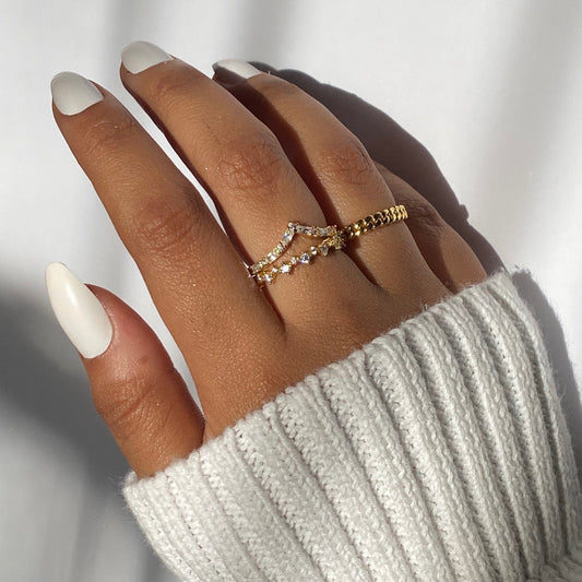 Gold chevron stacking ring with zigzag V design and tiny round stones on hand