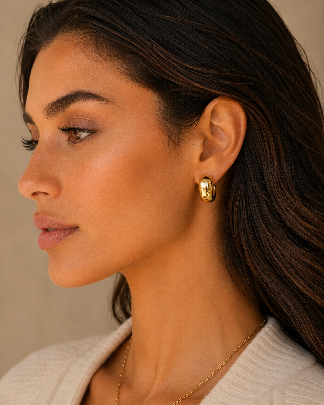 Gold dome hoop earrings on ear, curved polished design