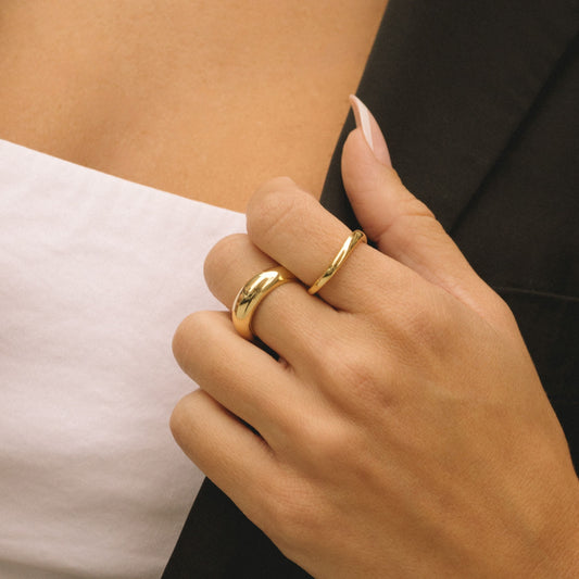 Gold-plated dome ring on hand, smooth rounded band with polished finish
