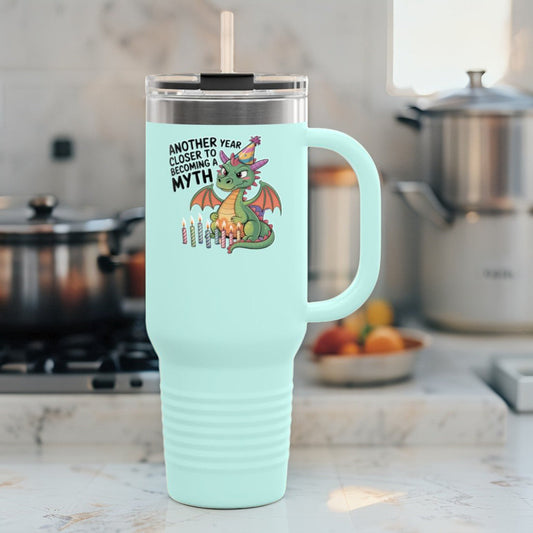 Insulated travel mug with mint body, dragon graphic, and white lid and handle