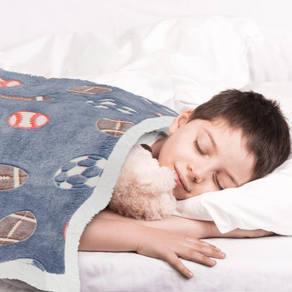 Gray sports blanket with football and soccer prints, child resting on bed