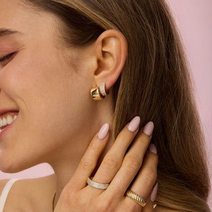 Gold small hoop earring with textured band detail on ear