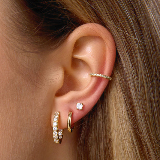 Small gold hoop earrings, one pavé and one plain, worn on ear