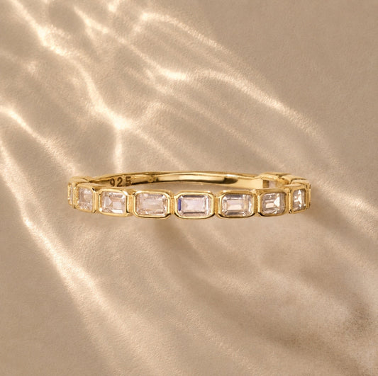 Gold-tone eternity ring with clear square stones in a row along the band