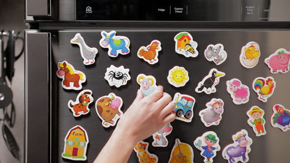 Assorted farm animal foam magnets displayed on a black refrigerator door