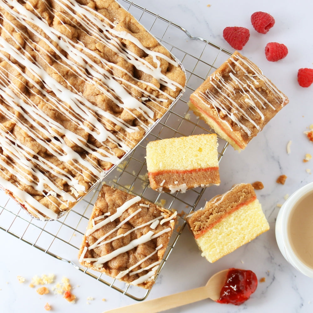 Assorted iced cake bars and cookies with sprinkles on cooling racks