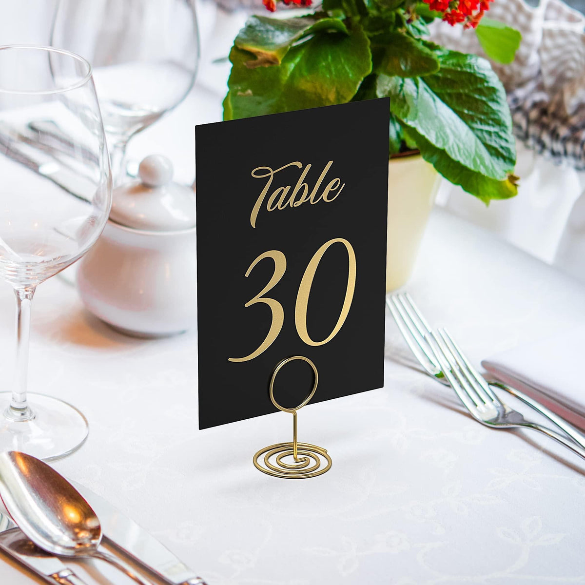 Black table number card with gold foil “Table 30” on a metal stand