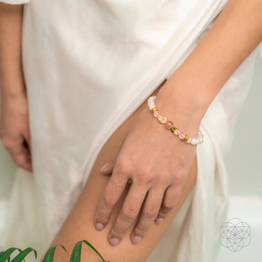 Gemstone beaded bracelet on wrist with rose quartz and moonstone stones and gold caps