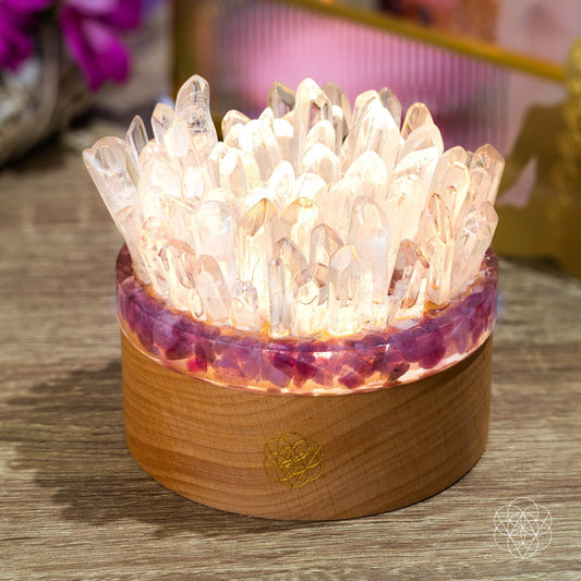 Crystal quartz and tourmaline lamp on wooden base with glowing clear point cluster