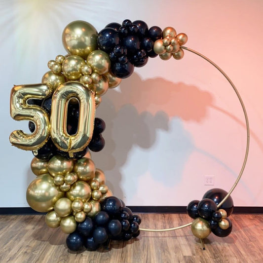 Metallic gold balloon number 5 and gold number 0 in a balloon arch arrangement