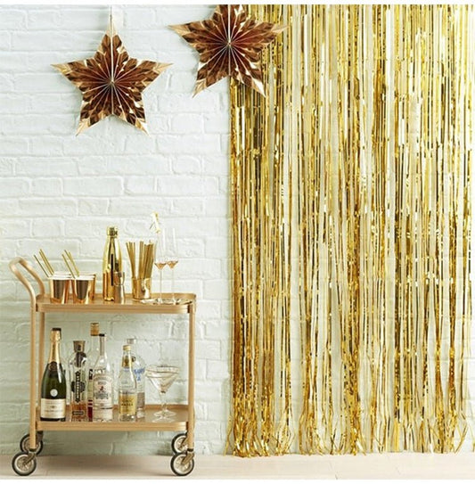 Gold metallic fringe curtain panels with shimmering vertical foil strands