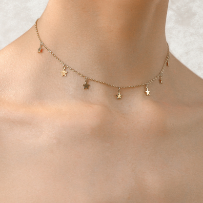 Gold star choker necklace with small stars spaced along the chain
