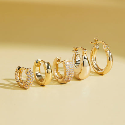 Pave huggie hoop earrings in gold and silver finishes, shown grouped together