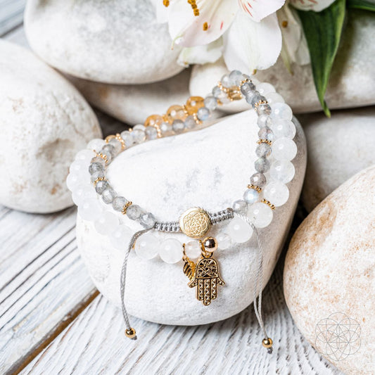 Beaded wealth bracelet with white stones, gold hamsa charm, and tassel ends