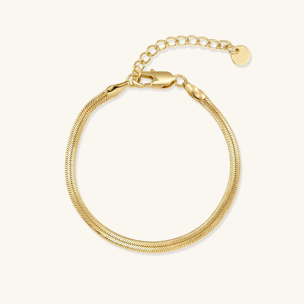 Gold-tone herringbone chain bracelet with clasp, laid flat on light background